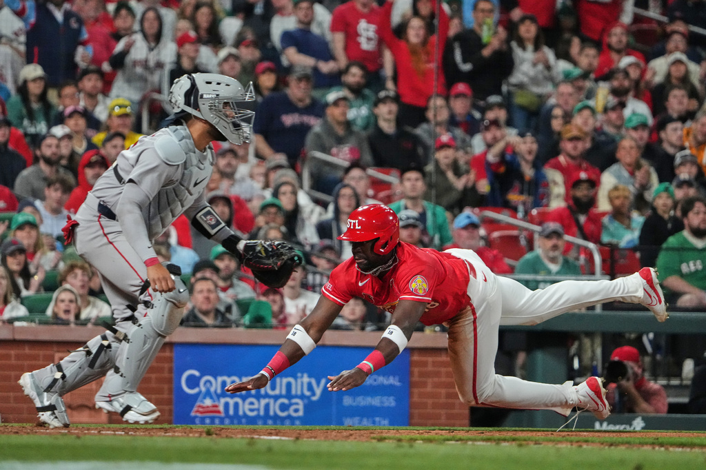 St. Louis Cardinals' Jordan Walker, right, scores past Boston Red Sox catcher Carlos Narvaez during the fifth inning of a baseball game Friday, April 10, 2026, in St. Louis. (AP Photo/Jeff Roberson)