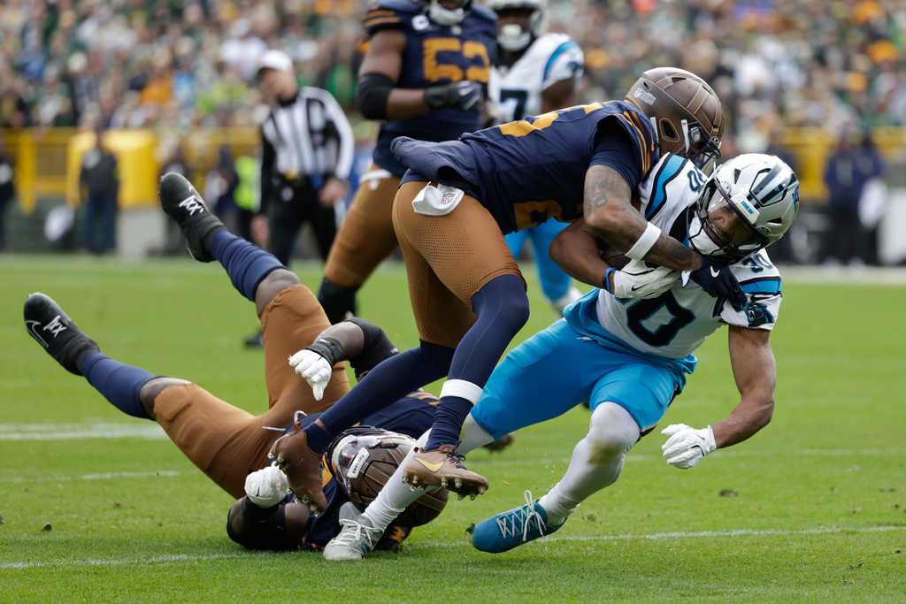 Green Bay Packers cornerback Keisean Nixon, front top, tackles Carolina Panthers running back Chuba Hubbard (30) during the second half of an NFL football game Sunday, Nov. 2, 2025, in Green Bay, Wis. (AP Photo/Matt Ludtke)
