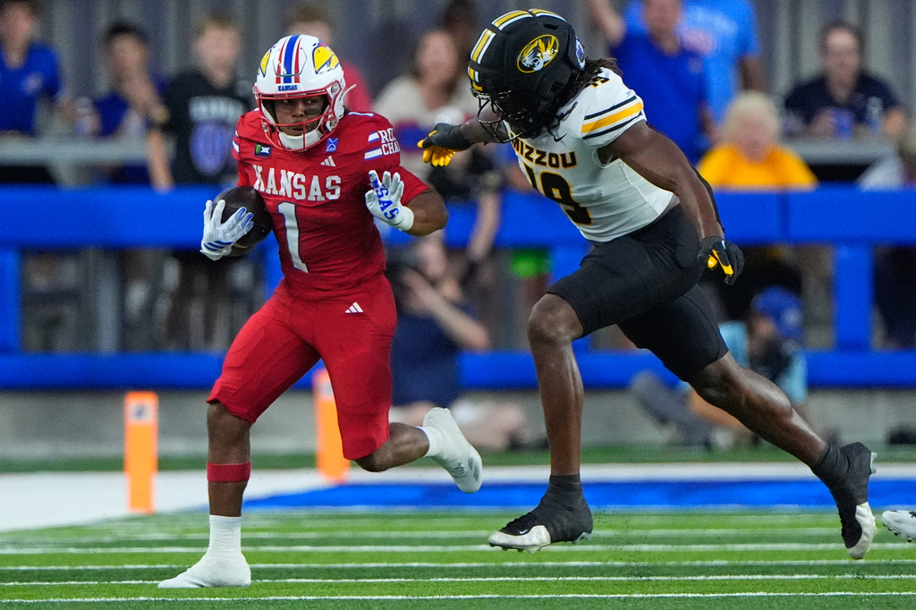 Kansas running back Dylan Edwards (1) gets past Missouri edge Darris Smith as he runs the ball during the first half of an NCAA college football game Friday, Sept. 11, 2026, in Lawrence, Kan. (AP Photo/Charlie Riedel)