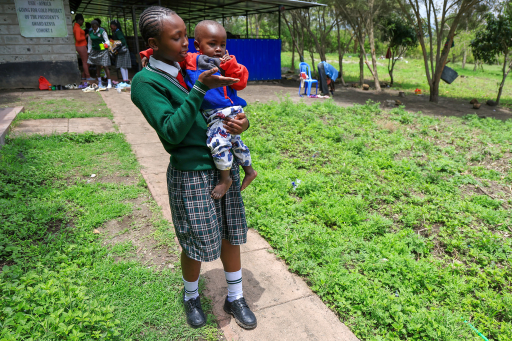 Valarie Wairimu, 19, interacts with her son, Kayden Darmain during breaktime at Greenland Girls School in Kiserian, Kajiado, Kenya, March 5, 2026. (AP Photo/Andrew Kasuku)