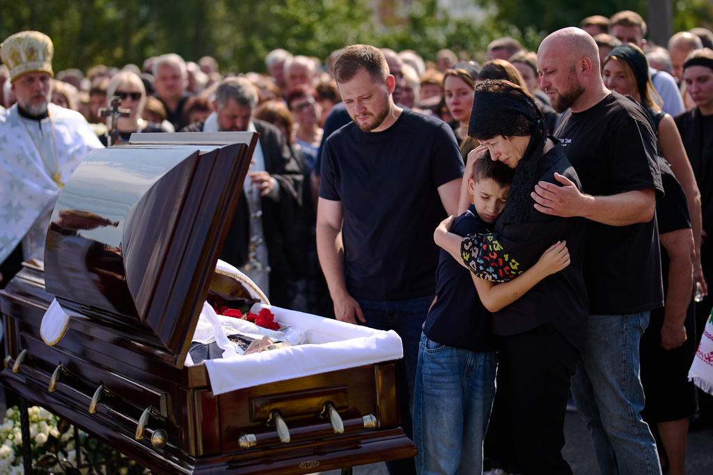 Relatives mourn Taras Didych, head of the Dmytrivska community in Kyiv region, who was killed while going to help local residents following a Russian drone attack during his funeral in Myla, on the outskirts of Kyiv, Monday, Aug. 31, 2026. (AP Photo/Francisco Seco)