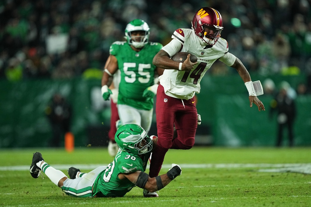 Washington Commanders quarterback Josh Johnson (14) is brought down by Philadelphia Eagles linebacker Jihaad Campbell (30) during the second half of an NFL football game Sunday, Jan. 4, 2026, in Philadelphia. (AP Photo/Matt Rourke)