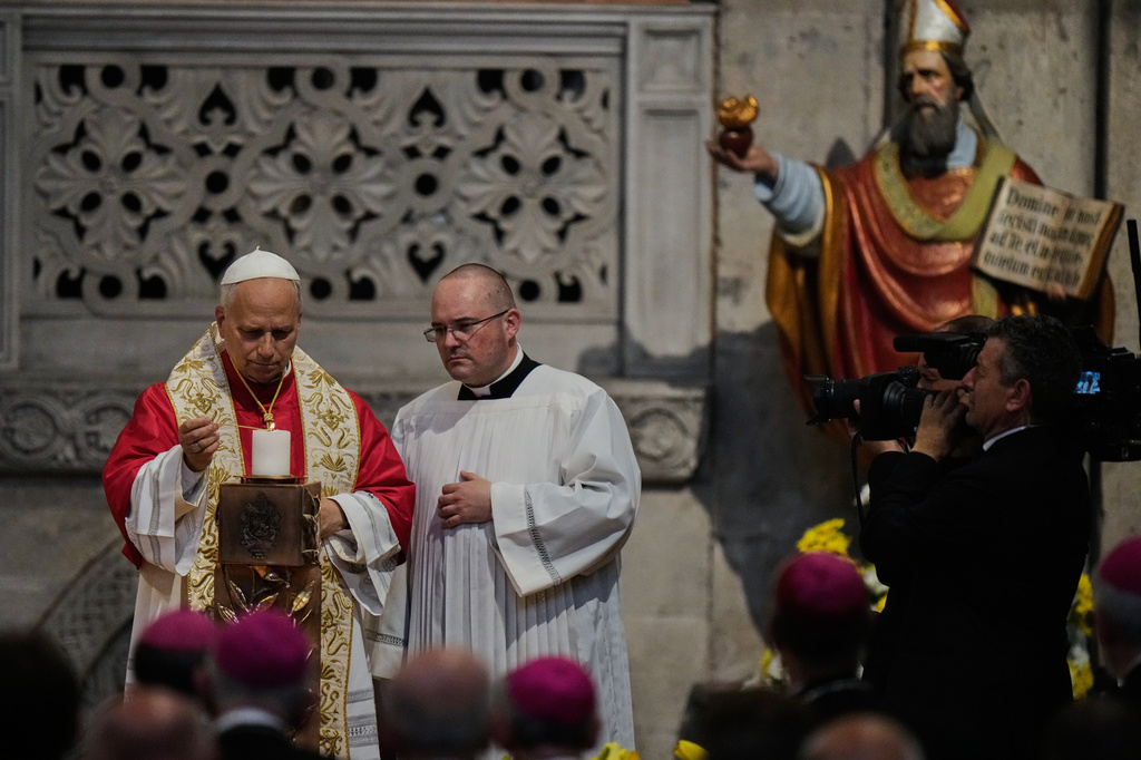 Pope Leo XIV light a candle as he visits the San Pietro in Ciel d'Oro Basilica in Pavia, northern Italy, Saturday, June 20, 2026. (AP Photo/Luca Bruno)