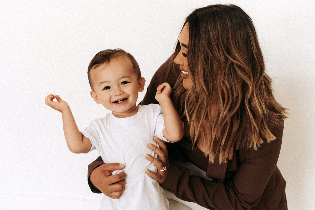 In this photo provided by Madison Kennedy, Dani Derner, 30, of Dripping Springs, Texas, holds her son, Liam, in July 2022. Liam was diagnosed with autism spectrum disorder at age 2. (Madison Kennedy via AP)