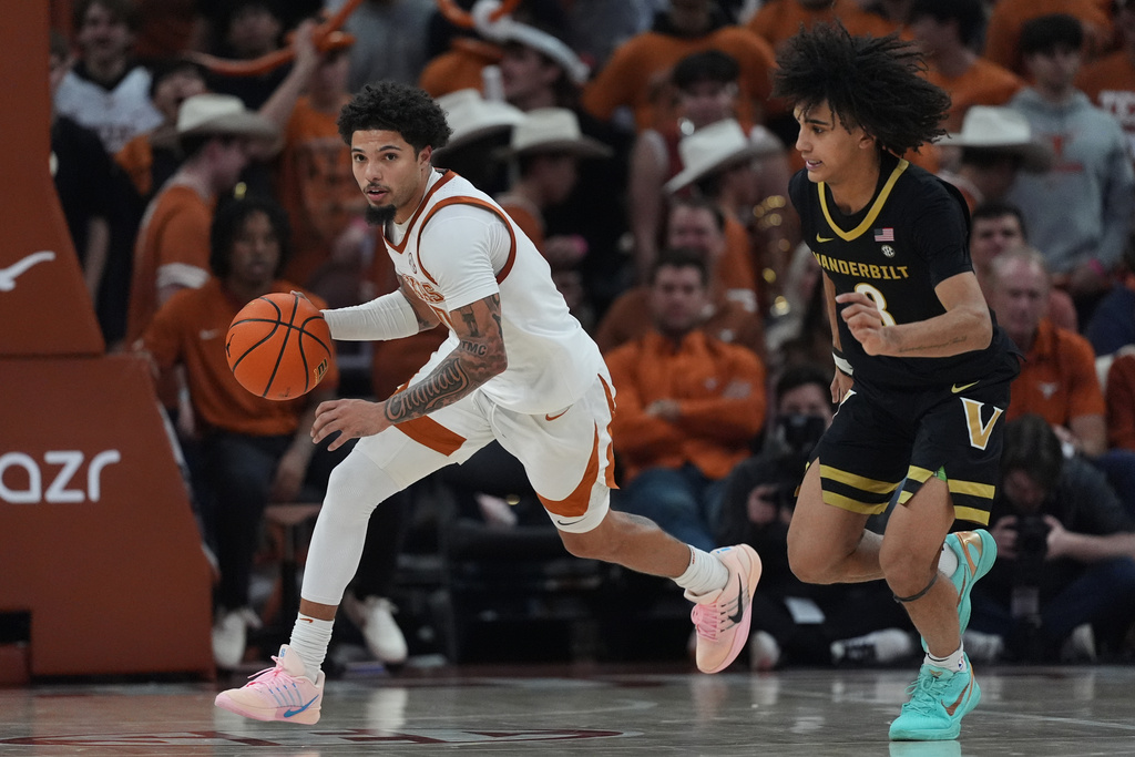Texas guard Jordan Pope (0) drives around Vanderbilt guard Tyler Tanner (3) during the second half of an NCAA college basketball game in Austin, Texas, Wednesday, Jan. 14, 2026. (AP Photo/Eric Gay)