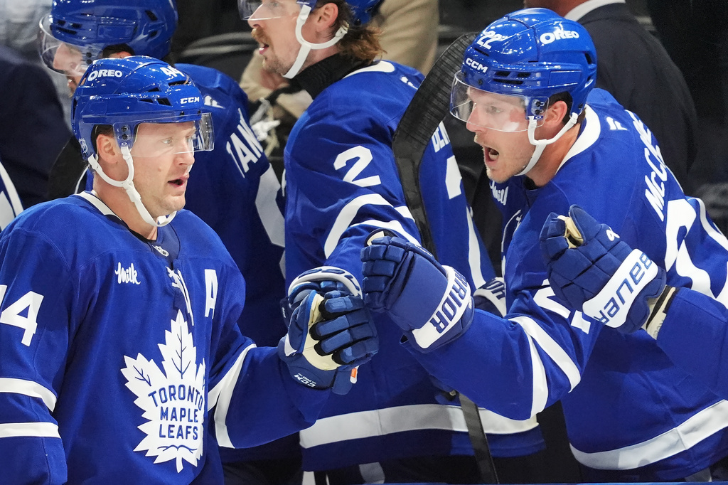 Toronto Maple Leafs' Morgan Rielly (left) celebrates his goal against the Montreal Canadiens with Jake McCabe (22) during third period NHL hockey action in Toronto on Wednesday, Oct. 8, 2025. (Frank Gunn/The Canadian Press via AP)