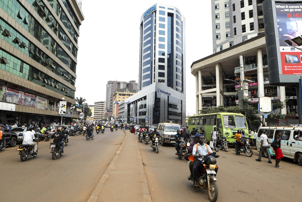 FILE - Drivers of motorcycle taxis, known locally as boda-bodas, ride with passengers on a street of Kampala, Uganda, on July 18, 2024. (AP Photo/Hajarah Nalwadda, File)