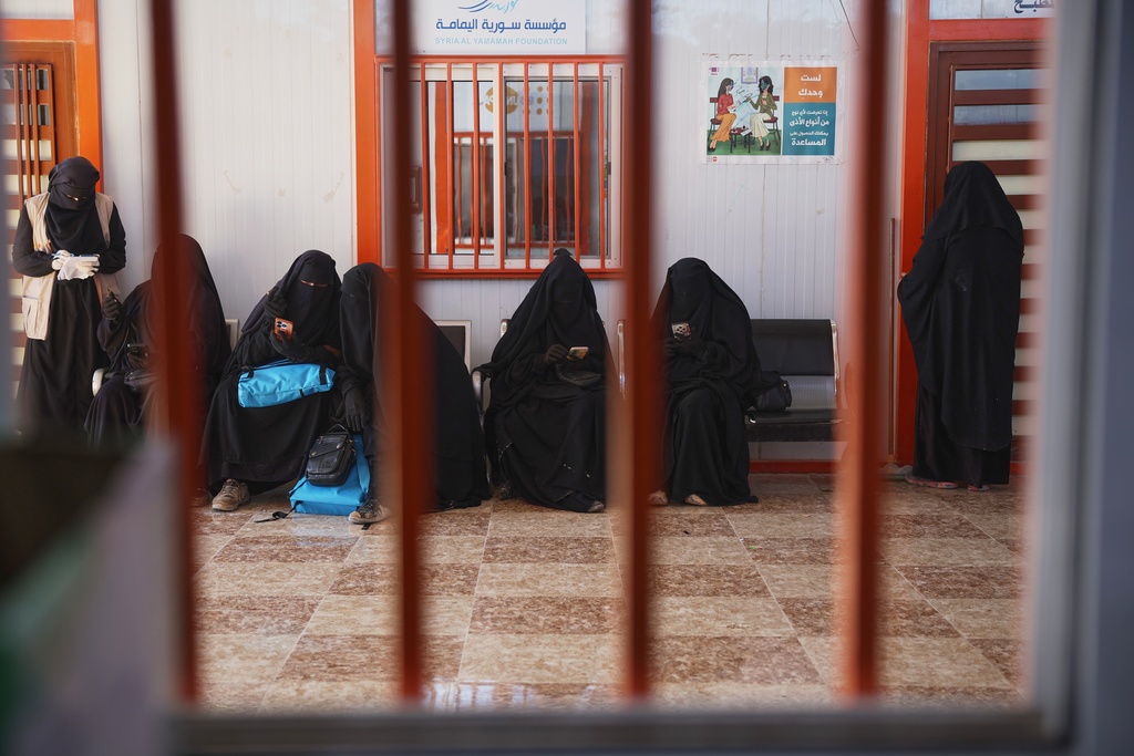 Women wait at a medical center in the al-Hol camp, one of the detention facilities holding thousands of Islamic State group members and their families, now under the control of the Syrian government following the withdrawal of the Syrian Democratic Forces (SDF), in al-Hassakeh province, northeastern Syria, Wednesday, Feb. 4, 2026. (AP Photo/Ghaith Alsayed)