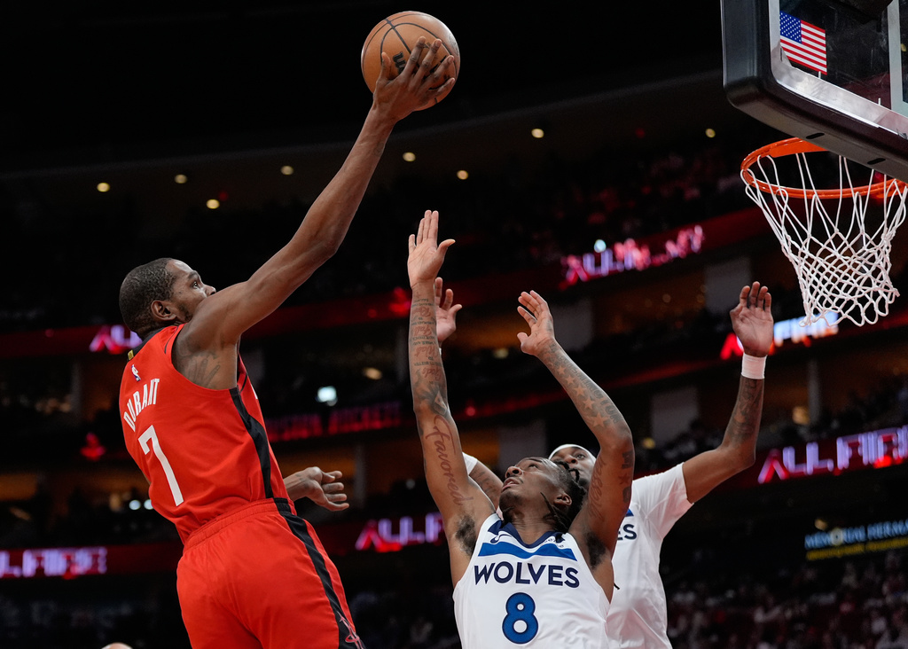 Houston Rockets forward Kevin Durant (7) shoots against Minnesota Timberwolves guard Bones Hyland (8) and forward Jaden McDaniels (3) during the first half of an NBA basketball game in Houston, Friday, Jan. 16, 2026. (AP Photo/Ashley Landis)
