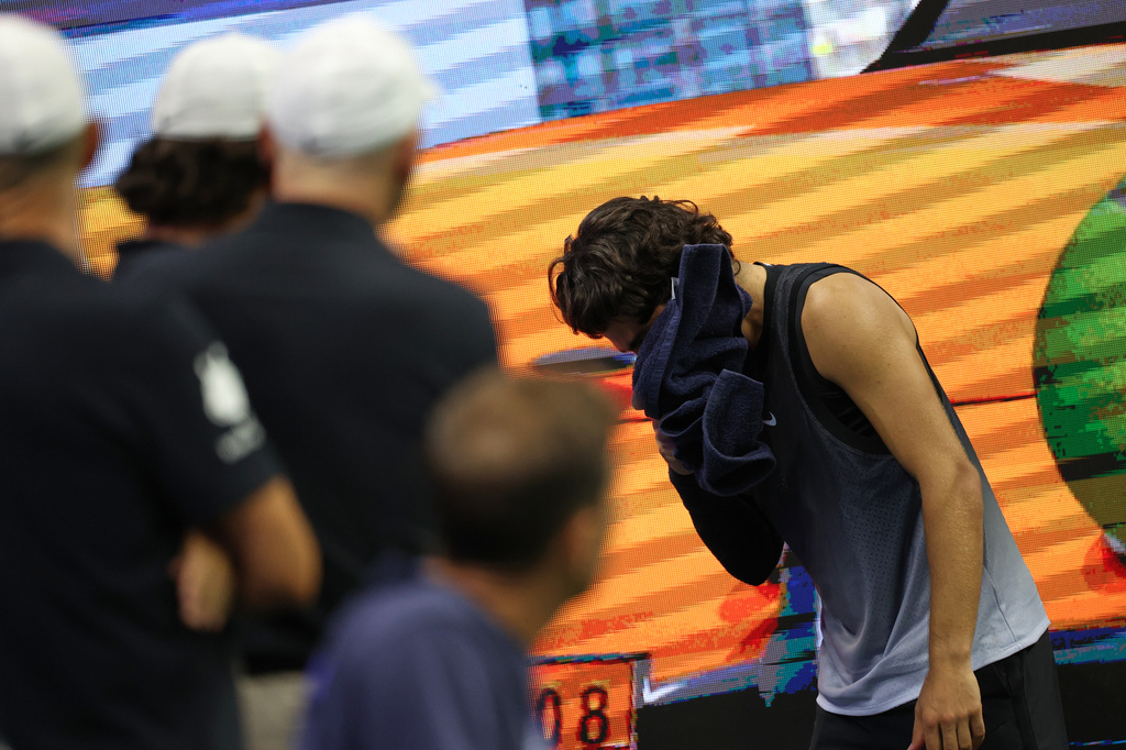Carlos Alcaraz, of Spain, vomits into a towel after the fourth set against Ben Shelton, of the United States, during the quarterfinal round of the U.S. Open tennis championships, early Wednesday, Sept. 9, 2026, in New York. (AP Photo/Heather Khalifa)