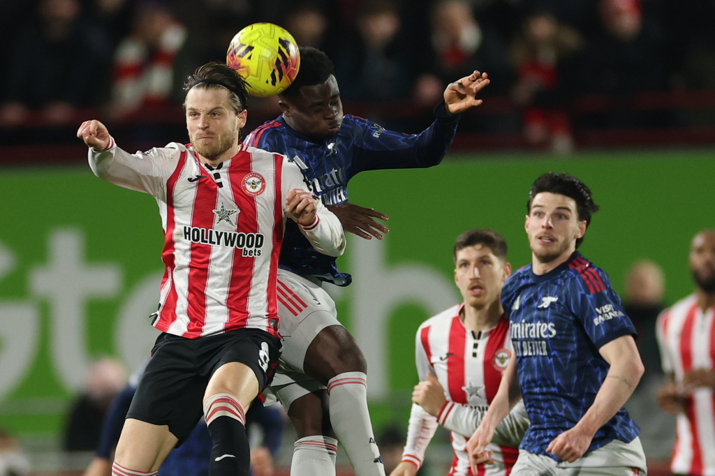 Brentford's Ethan Pinnock, left, and Arsenal's Bukayo Saka jump for the ball during the English Premier League soccer match between Brentford and Arsenal in London, Thursday, Feb. 12, 2026. (AP Photo/Ian Walton)