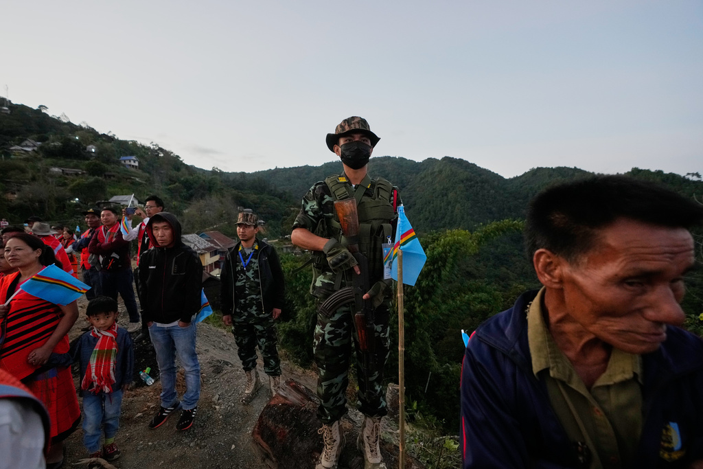 An armed cadre National Socialist Council of Nagaland (Isak-Muivah) stands guard as a crowd waits to greet Thuingaleng Muivah, a top Naga insurgent leader, in Somdal village, in the northeastern Indian state of Manipur, Wednesday, Oct. 22, 2025. (AP Photo/Anupam Nath)