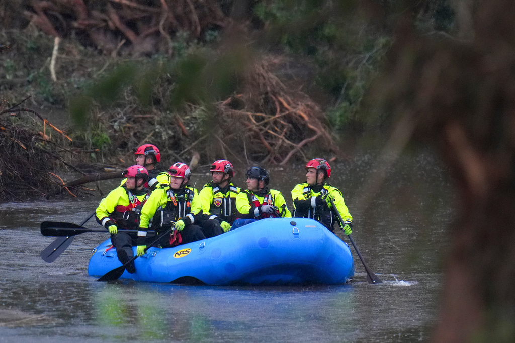 FILE - Officials ride a boat as they arrive to assist with a recovery effort at Camp Mystic along the Guadalupe River, July 6, 2025, in Hunt, Texas, after a flash flood swept through the area. (AP Photo/Julio Cortez, File