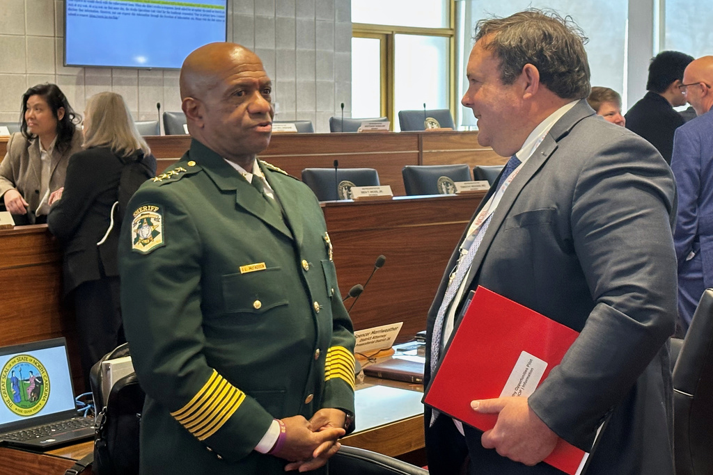 Mecklenburg County Sheriff Garry McFadden, left, speaks with state Rep. Eric Ager, D-Buncombe, during a break in the North Carolina House Select Committee on Oversight and Reform meeting at the Legislative Building in Raleigh, N.C., Monday, Feb. 9, 2026 (AP Photo/Gary D. Robertson)