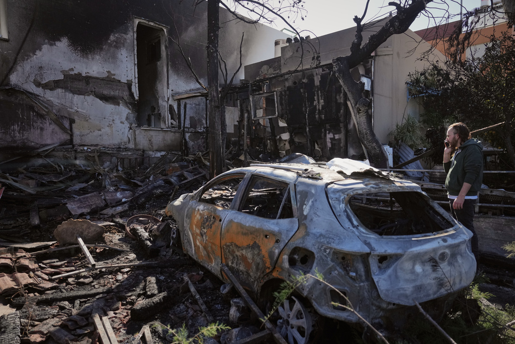 Residents inspect a house damaged yesterday by a projectiles launched from Lebanon in Nahariya, northern Israel, Tuesday, March 17, 2026. (AP Photo/Ariel Schalit)