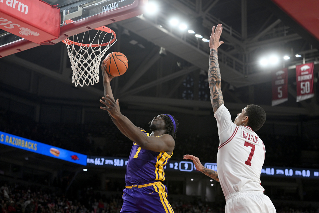 LSU forward Mike Nwoko (1) drives past Arkansas forward Trevon Brazile (7) to score during the first half of an NCAA college basketball game Saturday, Jan. 24, 2026, in Fayetteville, Ark. (AP Photo/Michael Woods)
