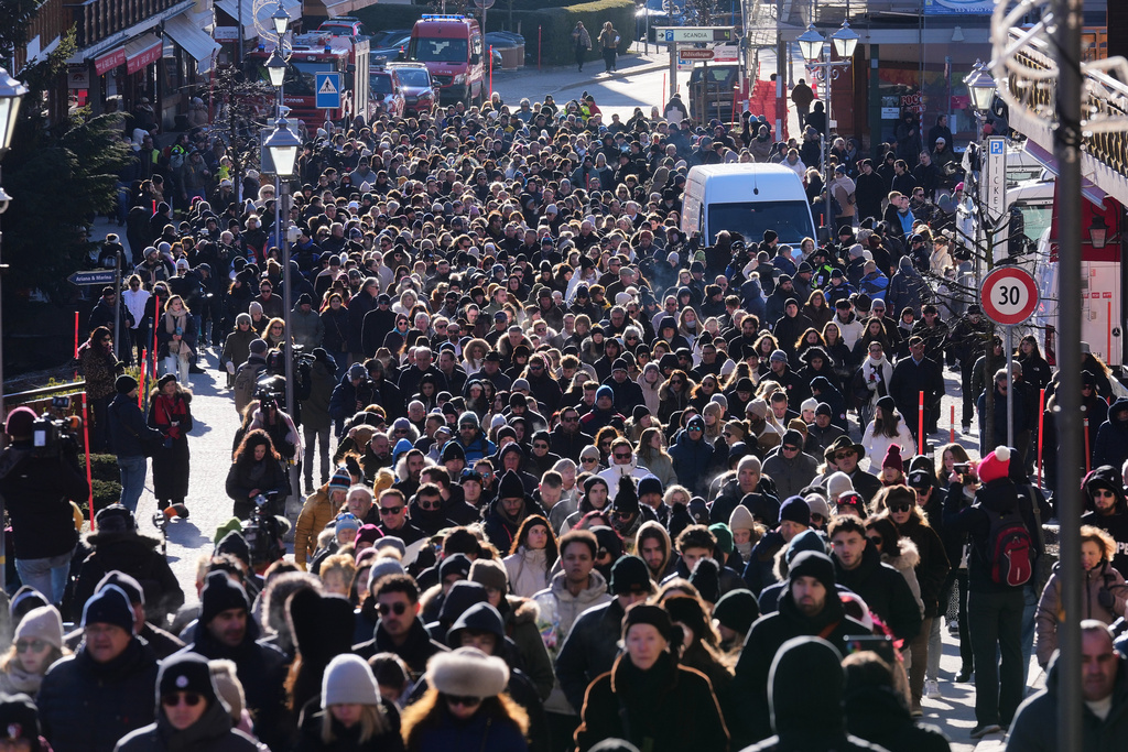 People walk during a memorial procession in Crans-Montana, Swiss Alps, Switzerland, Sunday, Jan. 4, 2026, after a devastating fire in Le Constellation bar left dead and injured during the New Year's celebrations. (AP Photo/ Antonio Calanni)