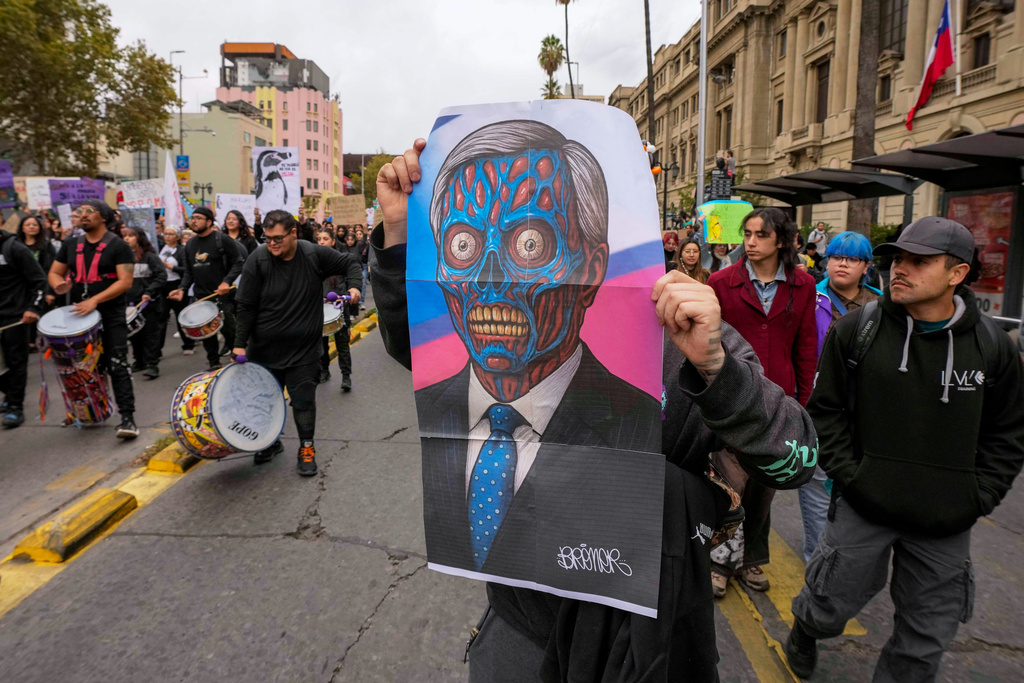 A protester holds an image representing Chile's President Jose Antonio Kast during a march on World Water Day demanding greater environmental protection and animal welfare in Santiago, Chile, Sunday, March 22, 2026. (AP Photo/Esteban Felix)