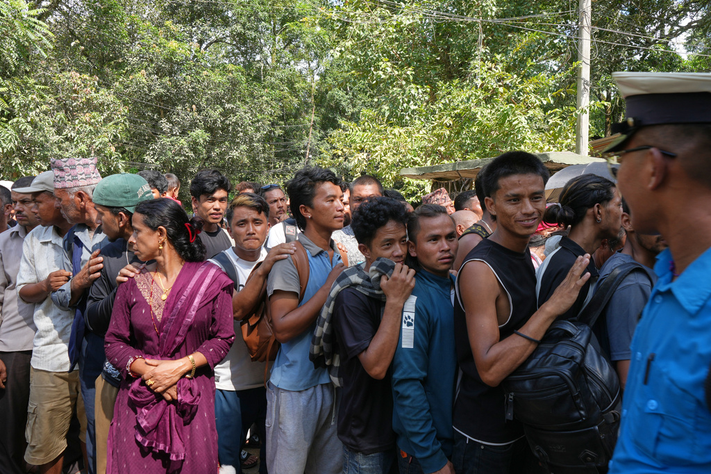 People line up outside an army camp after flash flooding in Nepal's Nuwakot district, Friday, Aug. 28, 2026. (AP Photo/Rajesh Kumar Singh)
