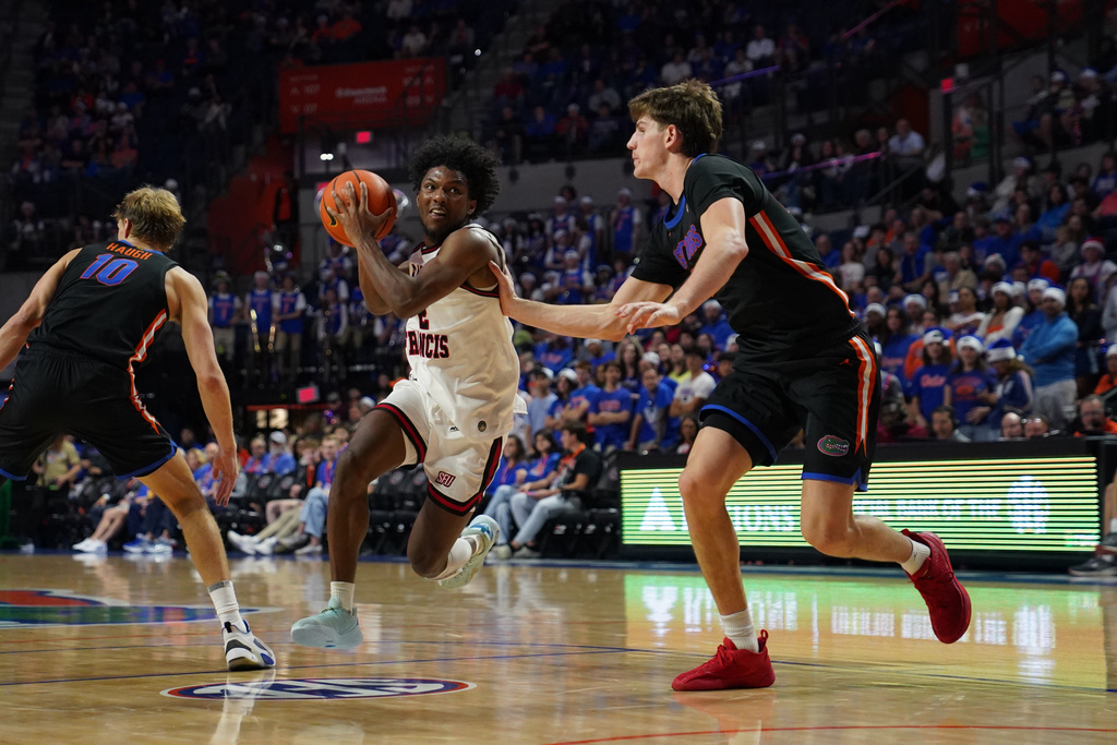Florida forward/center Alex Condon (right) guards against Saint Francis guard Zion Russell (left) during the first half of an NCAA college basketball game Wednesday, Dec. 17, 2025, in Gainesville, Fla. (AP Photo/Morgan Hurd)