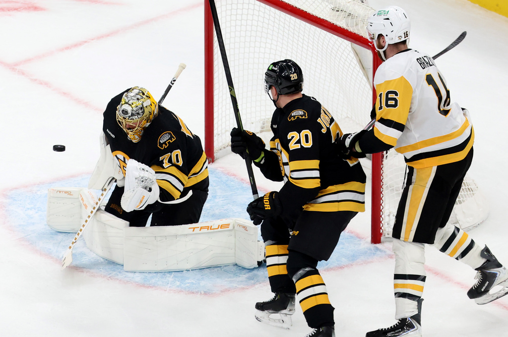 Boston Bruins goaltender Joonas Korpisalo (70) makes a glove-save as teammate Henri Jokiharju (20) and Pittsburgh Penguins right wing Justin Brazeau (16) watch during the second period of an NHL hockey game, Sunday, Jan. 11, 2026, in Boston. (AP Photo/Mark Stockwell)