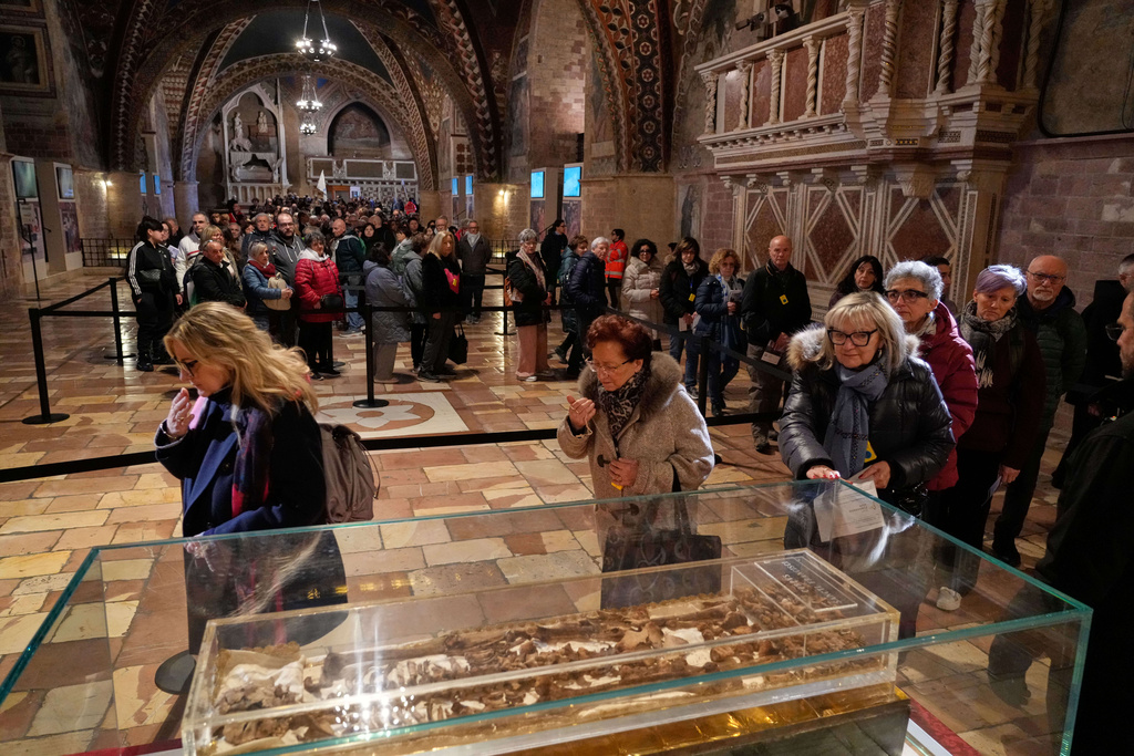 Pilgrims honor the bones of St. Francis during the first public display inside the St. Francis Basilica, marking the 800th anniversary of the saint death, in Assisi, Italy, Sunday, Feb. 22, 2026.(AP Photo/Gregorio Borgia)