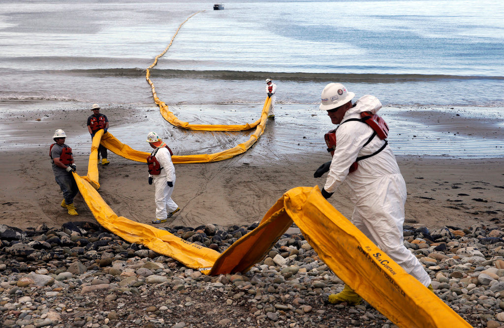 FILE - Workers prepare an oil containment boom at Refugio State Beach, north of Goleta, Calif., on May 21, 2015, two days after an oil pipeline ruptured, polluting beaches and killing hundreds of birds and marine mammals. (AP Photo/Jae C. Hong, File)