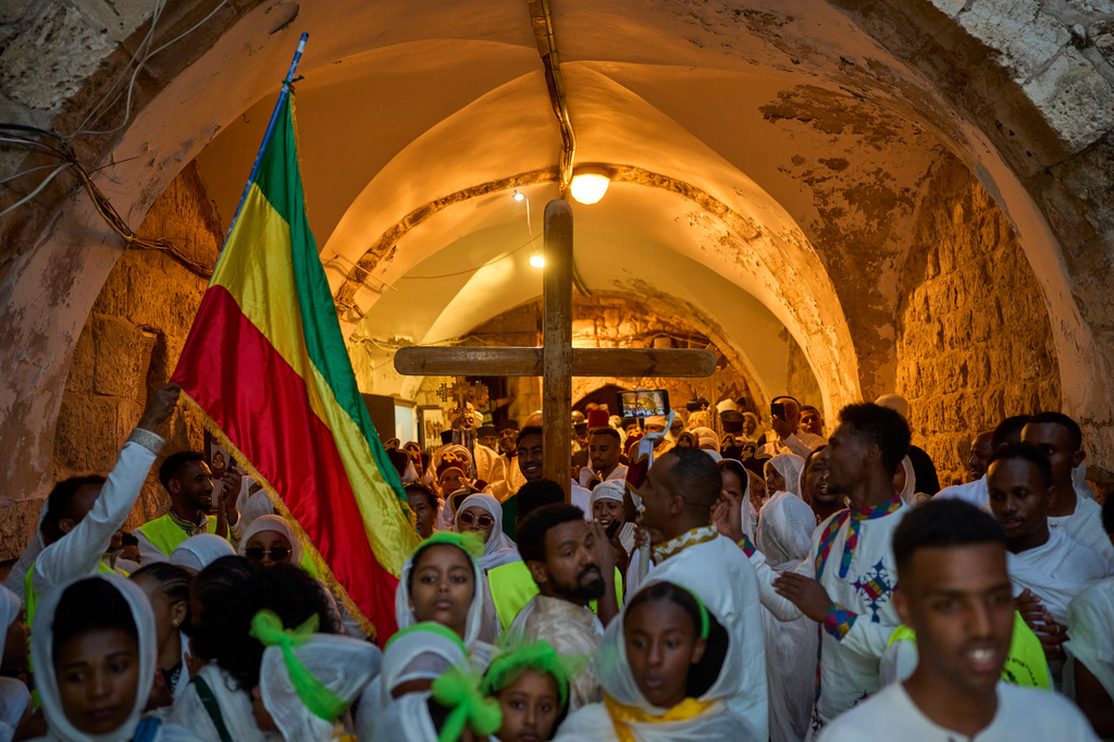 Ethiopian Orthodox Christian worshippers carry a crucifix to celebrate the eve of the Meskel holiday at the Ethiopian monks' village, Deir Al‑Sultan, located on the rooftop of the Church of the Holy Sepulcher in Jerusalem's Old City, Saturday, Sept. 26, 2026. (AP Photo/Ohad Zwigenberg)