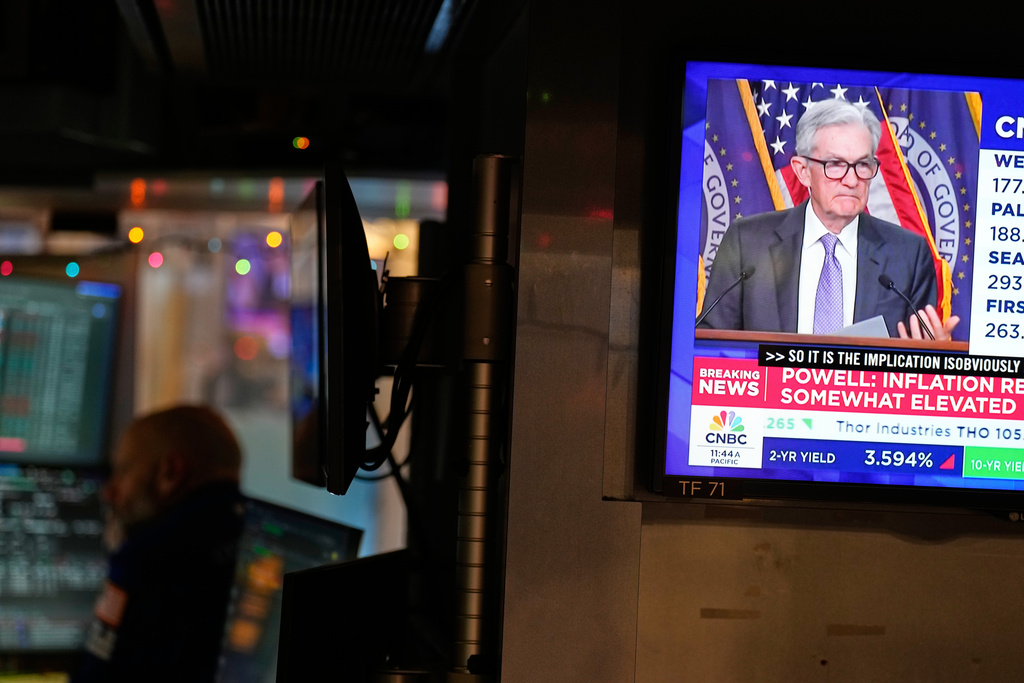 A television on the floor at the New York Stock Exchange in New York, display a news conference with Fed chairman Jerome Powell, Wednesday, Dec. 10, 2025. (AP Photo/Seth Wenig)