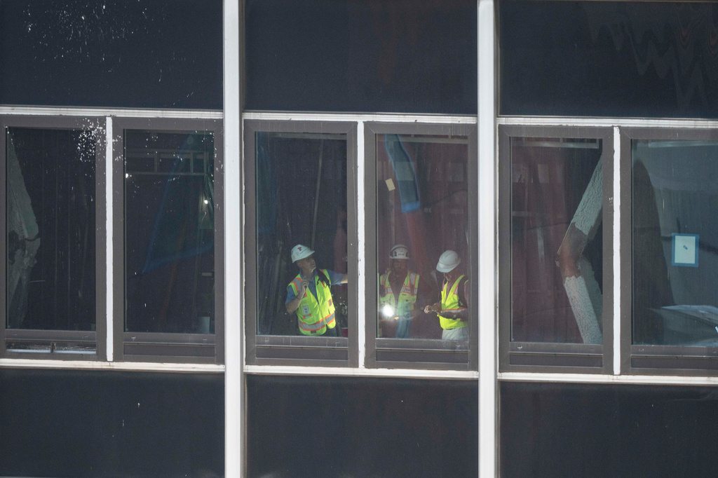 People inspect a buckled support beam inside 235 East 42nd Street, Wednesday, July 8, 2026, in New York. (AP Photo/Yuki Iwamura)