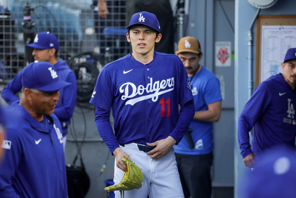 Los Angeles Dodgers starting pitcher Roki Sasaki (11) stands in the dugout before a spring training baseball game against the Los Angeles Angels, Monday, March 23, 2026, in Los Angeles. (AP Photo/Ryan Sun)