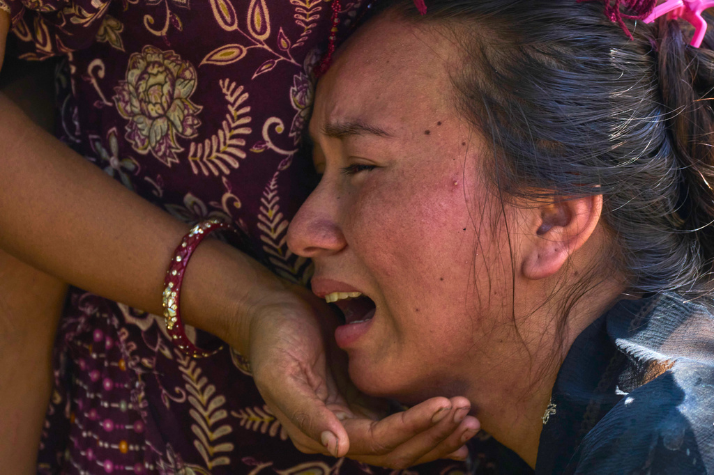 A girl cries as she waits for news of relatives missing after flash floods in Bidur, Nepal's Nuwakot district, Thursday, Aug. 27, 2026. (AP Photo/Niranjan Shrestha)