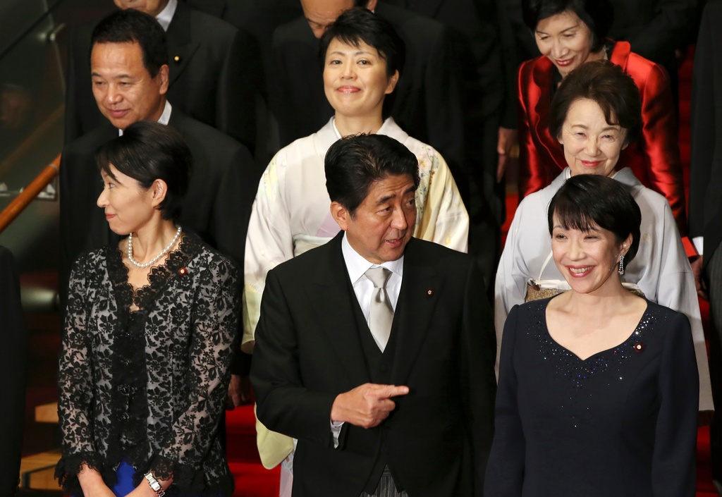 FILE - Japan's Prime Minister Shinzo Abe, front row center, and his new Cabinet members pose for a group photo following the first Cabinet meeting at the prime minister's official residence in Tokyo, Sept. 3, 2014. The ministers from the right front row are Internal Affairs Minister Sanae Takaichi, Abe, Trade Minister Yuko Obuchi, from the right second row, Minister in charge of Japanese Abducted by North Korea Eriko Yamatani, Minister in charge of Promoting Women Haruko Arimura, and Minister in charge of Economic Revitalization Akira Amari. At right top is Justice Minister Midori Matsushima. (AP Photo/Eugene Hoshiko, File)