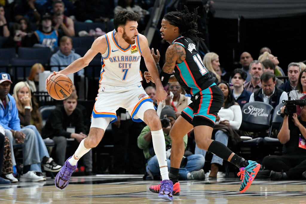Oklahoma City Thunder center Chet Holmgren (7) handles the ball against Memphis Grizzlies guard Ja Morant in the first half of an NBA basketball game, Sunday, Nov. 9, 2025, in Memphis, Tenn. (AP Photo/Brandon Dill)
