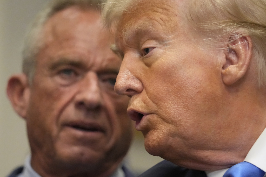 President Donald Trump speaks in the Roosevelt Room of the White House, Monday, Sept. 22, 2025, in Washington, as Health and Human Services Secretary Robert F. Kennedy Jr. listens. (AP Photo/Mark Schiefelbein)