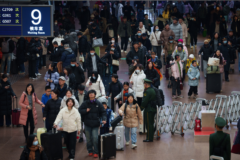 Passengers crowd a concourse at a railway station as they return home during the Lunar New Year holiday in Beijing, China, Tuesday, Feb. 10, 2026. (AP Photo/Vincent Thian)