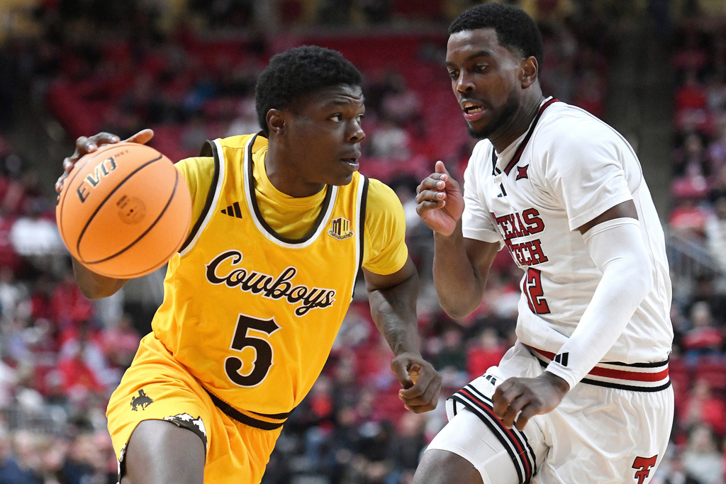 Wyoming guard Leland Walker (5) dribbles the ball while Texas Tech guard Donovan Atwell guards during the second half in an NCAA college basketball game, Sunday, Nov. 30, 2025, in Lubbock, Texas. (AP Photo/Annie Rice)