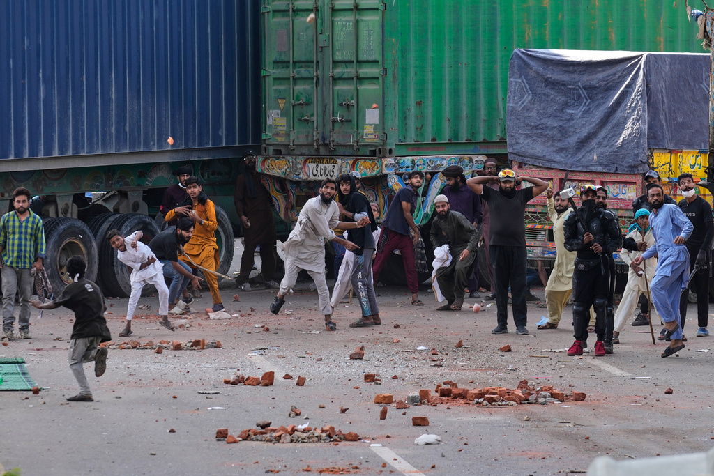 Supporters of Islamist party 'Tehreek-e-Labbaik Pakistan' throw stones toward police during clashes ahead of their pro-Palestinian march toward capital Islamabad, in Lahore, Pakistan, Friday, Oct. 10, 2025. (AP Photo/K.M. Chaudary)