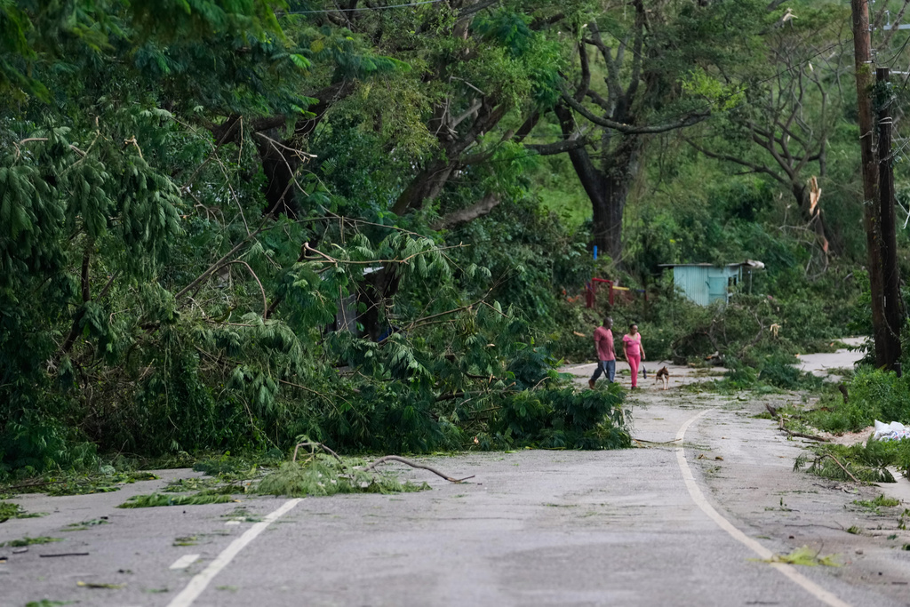 People walk along a road after Hurricane Melissa passed through Spurr Tree, Jamaica, Wednesday, Oct. 29, 2025. (AP Photo/Matias Delacroix),