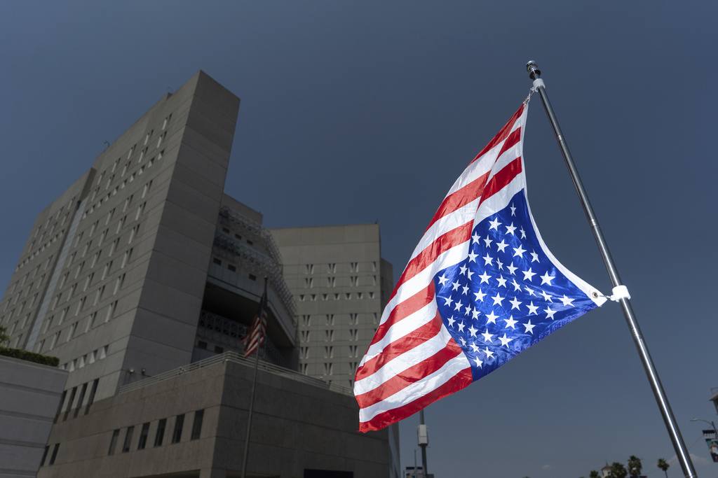 An upside-down American flag, a signal of distress and protest, hangs outside the Metropolitan Detention Center in Los Angeles, Saturday, July 19, 2025. (AP Photo/Jae C. Hong)