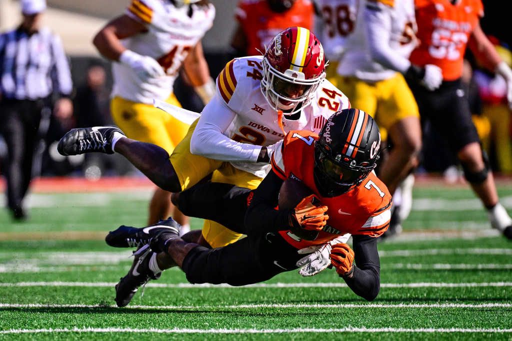 Iowa State defensive back Quentin Taylor (24) tackles Oklahoma State wide receiver Shamar Rigby (7) during the first half of an NCAA college football game, Saturday, Nov. 29, 2025, in Stillwater, Okla. (AP Photo/Gerald Leong)