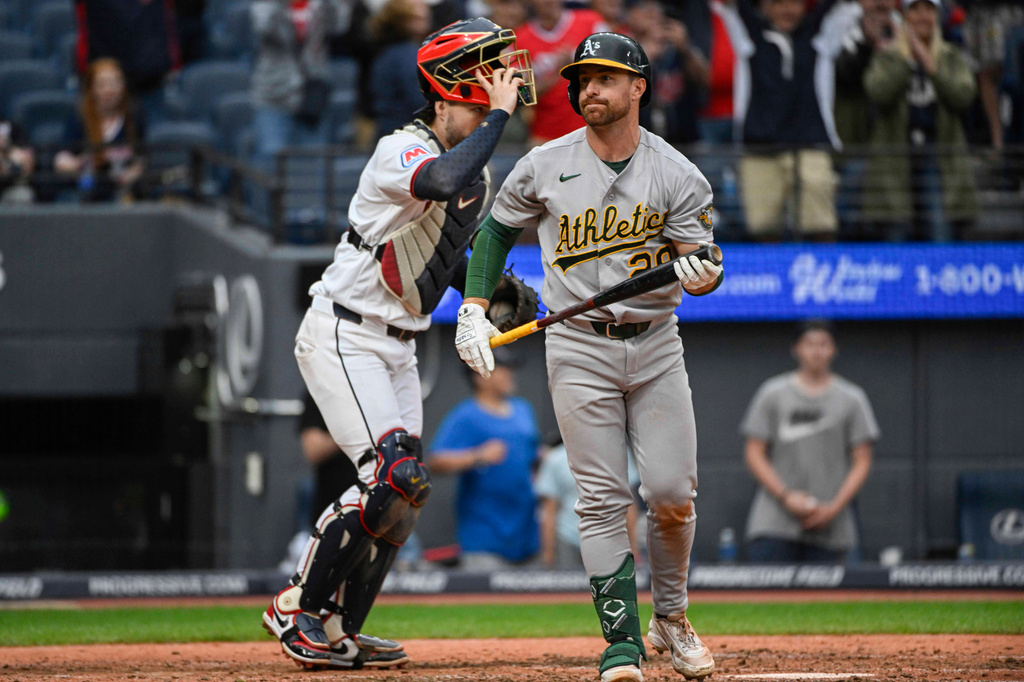 Athletics' Shea Langeliers, right, walks back to the dugout as Cleveland Guardians' Patrick Bailey, left, looks on after a strikeout by Cleveland Guardians relief pitcher Cade Smith for the final out of a baseball game, Sunday, Sept. 20, 2026, in Cleveland. (AP Photo/Phil Long)