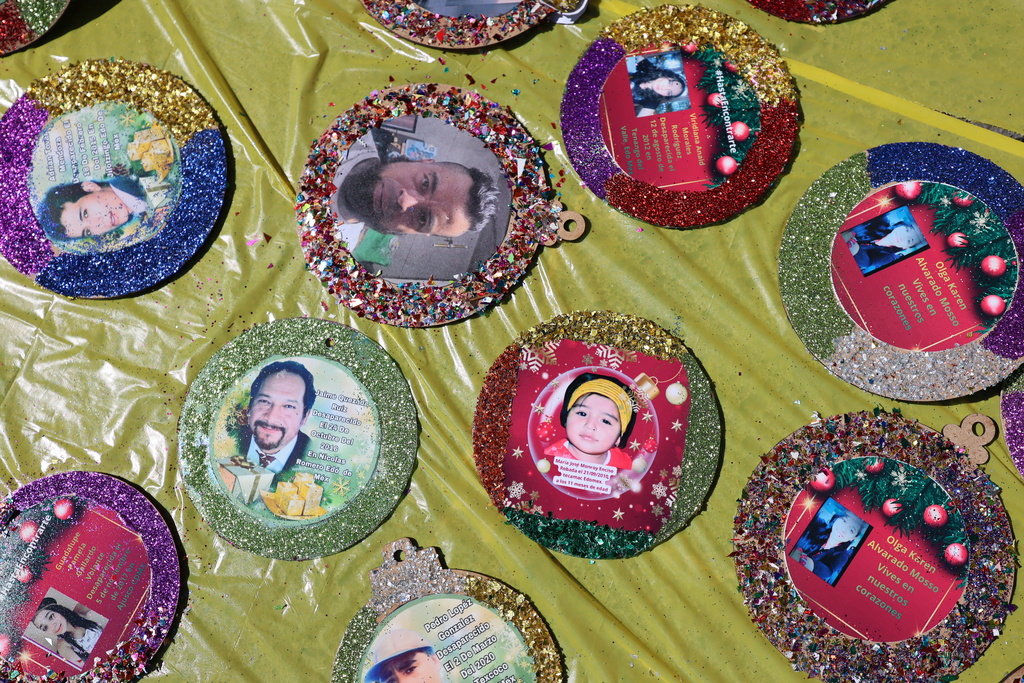 Christmas ornaments with photographs of the missing lay to dry before hanging on the Tree of Hope during an event organized by the diocese of Ecatepec at the Church of the Sacred Heart of San Cristobal in Ecatepec, State of Mexico, Monday, Nov. 17, 2025. (AP Photo/Ginnette Riquelme)