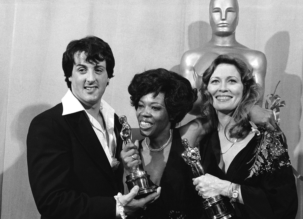 FILE - Actor and screenwriter Sylvester Stallone, left, poses with Eletha Finch, center, widow of actor Peter Finch, and actress Faye Dunaway at the Academy Awards in Los Angeles on March 28, 1977. (AP Photo/File)