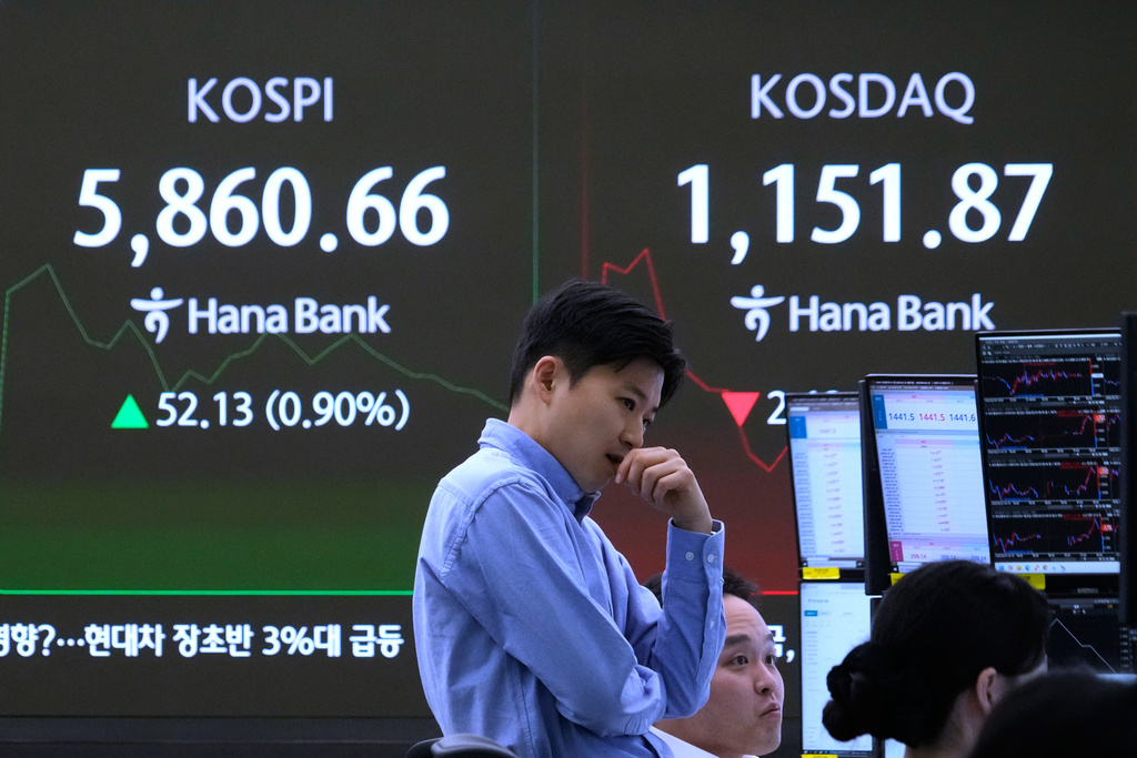 A currency traders reacts near a screen showing the Korea Composite Stock Price Index (KOSPI), left, and the foreign exchange rate between U.S. dollar and South Korean won at the foreign exchange dealing room of the Hana Bank headquarters in Seoul, South Korea, Monday, Feb. 23, 2026. (AP Photo/Ahn Young-joon)