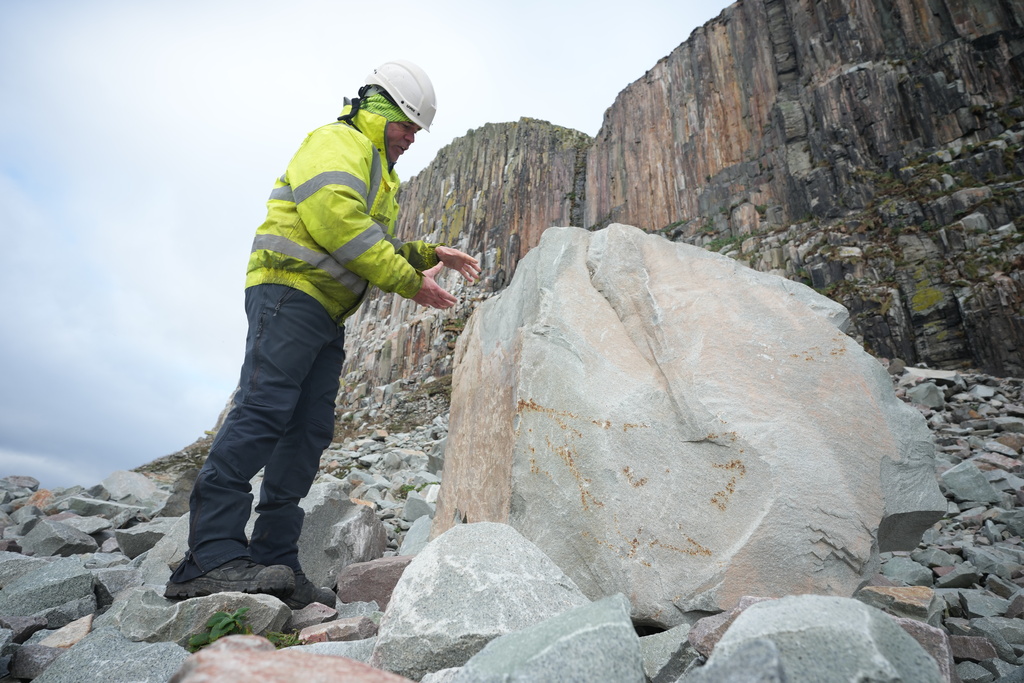 Jim English, Kays Curling Managing Director, looks at a boulder of granite on the island of Ailsa Craig, off the coast of Scotland, Monday, Nov. 10, 2025. (AP Photo/Alastair Grant)