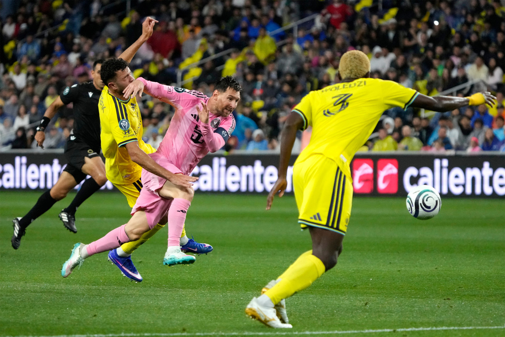 Inter Miami forward Lionel Messi, center, chases the ball as he is defended by Nashville SC midfielder Patrick Yazbek, left, and defender Maxwell Woledzi (3) in the first half of a CONCACAF Champions Cup Round of 16 soccer match Wednesday, March 11, 2026, in Nashville, Tenn. (AP Photo/Mark Humphrey)