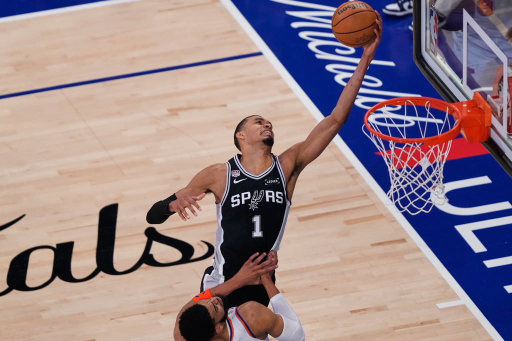 San Antonio Spurs forward Victor Wembanyama (1) pulls down a rebound over New York Knicks center Karl-Anthony Towns (32) during Game 3 of the NBA Finals basketball series, Monday, June 8, 2026, in New York. (AP Photo/Yuki Iwamura)