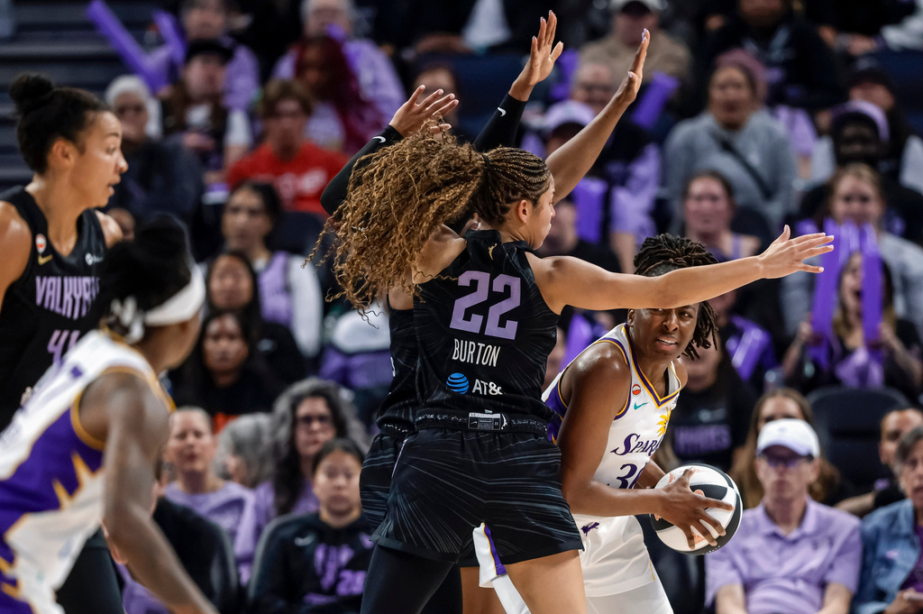 Los Angeles Sparks' Nneka Ogumwike, right, looks for help from a teammate as she is defended by Golden State Valkyries' Veronica Burton (22) in the first half of a WNBA basketball game Monday, June 15, 2026, in San Francisco. (Carlos Avila Gonzalez/San Francisco Chronicle via AP)