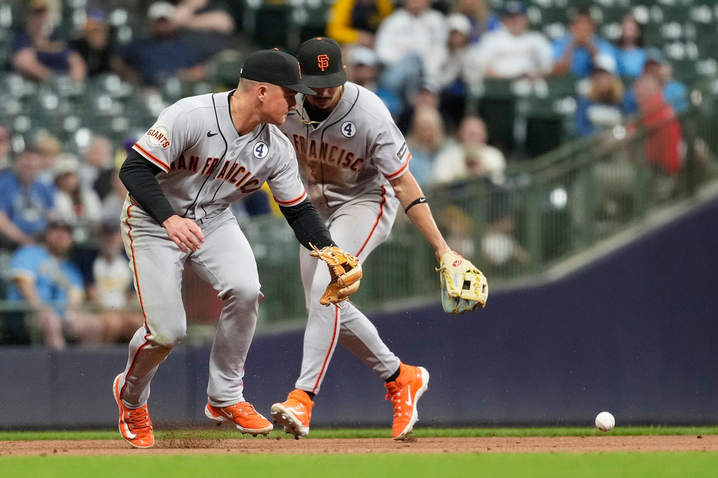 San Francisco Giants' Matt Chapman, left, and Willy Adames are unable to field a ground ball during the eighth inning of a baseball game against the Milwaukee Brewers, Tuesday, June 2, 2026, in Milwaukee. (AP Photo/Aaron Gash)